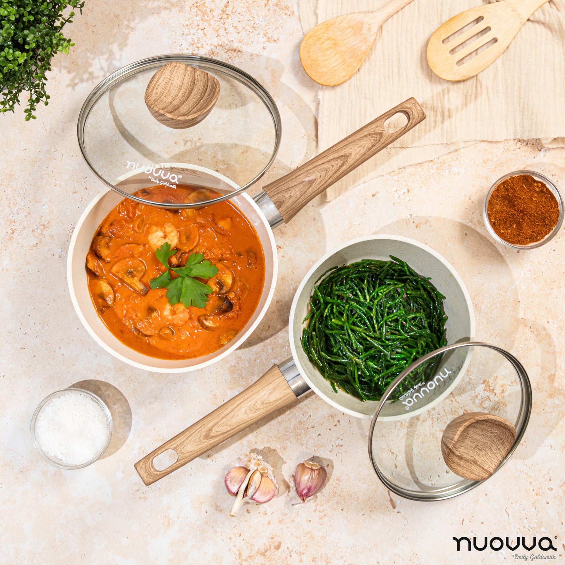 Nuovva 16cm and 18cm cream granite saucepan set with glass lids and wooden handles.
