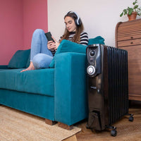 Black oil-filled radiator heater with wheels for portable home heating