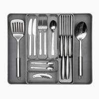 Grey adjustable cutlery drawer organizer with slotted knife holder and extendable sides for easy kitchen organization. 