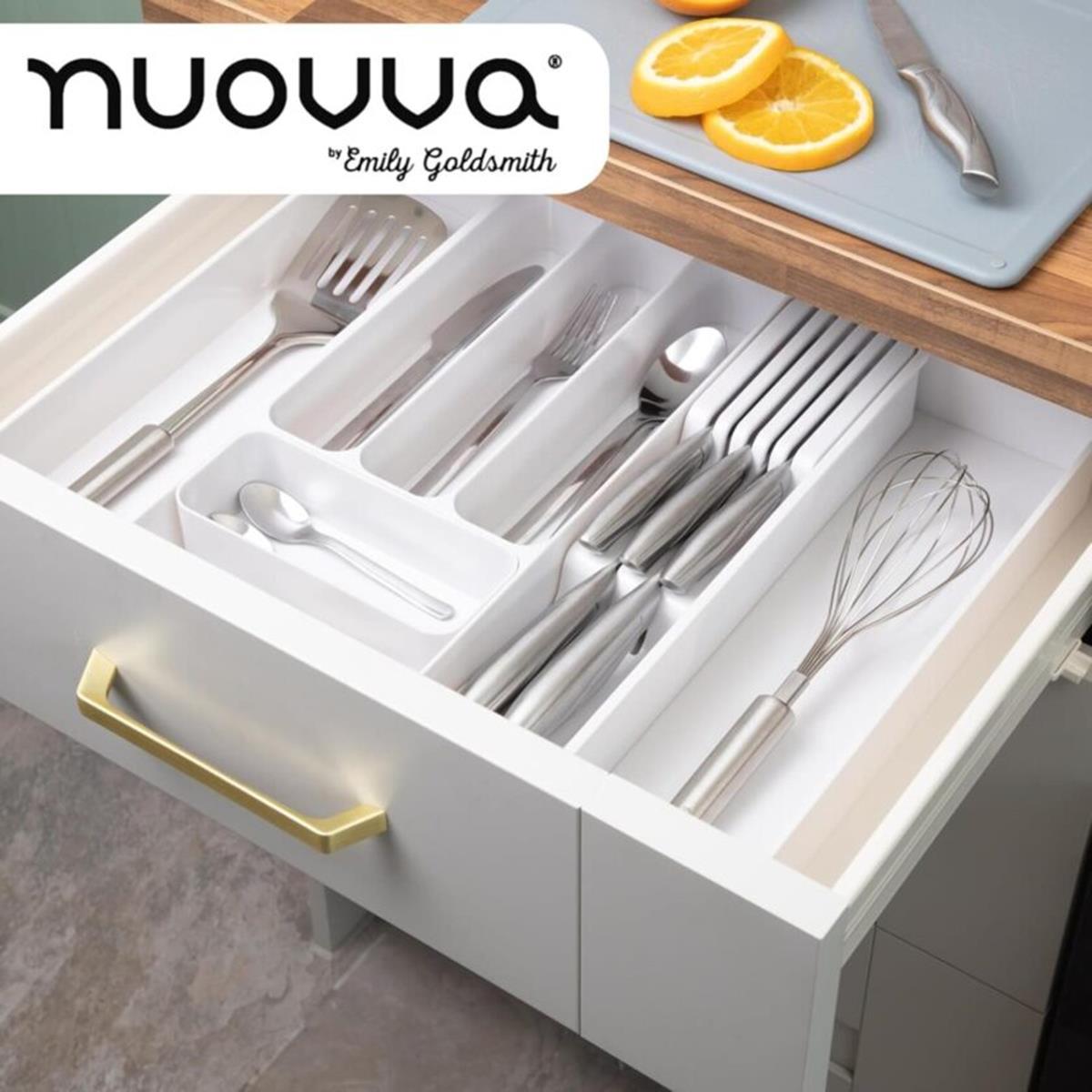 Adjustable cutlery organizer in a kitchen drawer with utensils and a whisk.