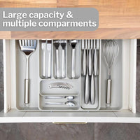 Light grey adjustable cutlery drawer with multiple compartments. 