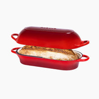 Red enameled cast iron bread pan with lid containing home baked bread. 