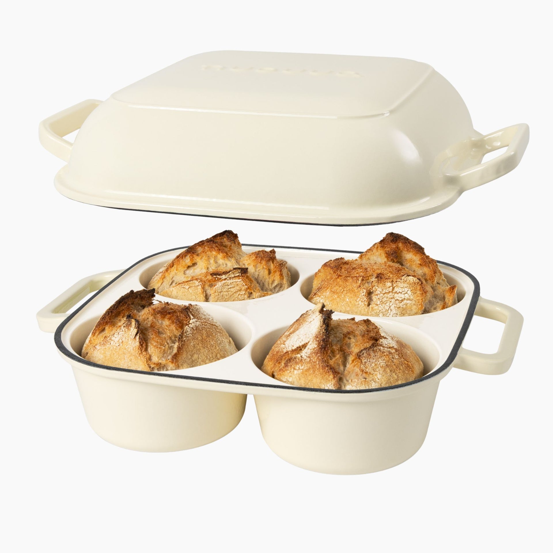 Cream cast iron bread loaf pan with four compartments containing bread loaves for home baked bread