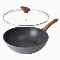 Grey marble wok pan with glass lid and wooden handles. 