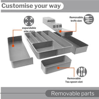 Gray kitchen cutlery organizer with removable parts and expandable slots.
