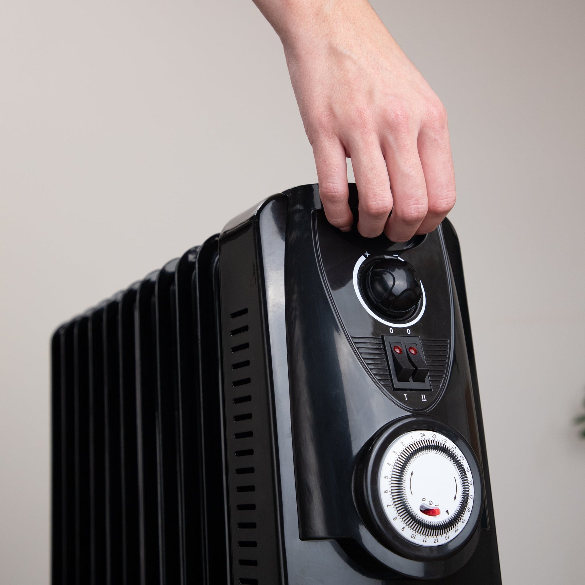 Black portable radiator with handle and adjustable controls. 