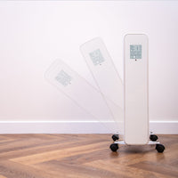 White touchscreen radiator heater with anti-tip feature and wheels for safe portable heating. 